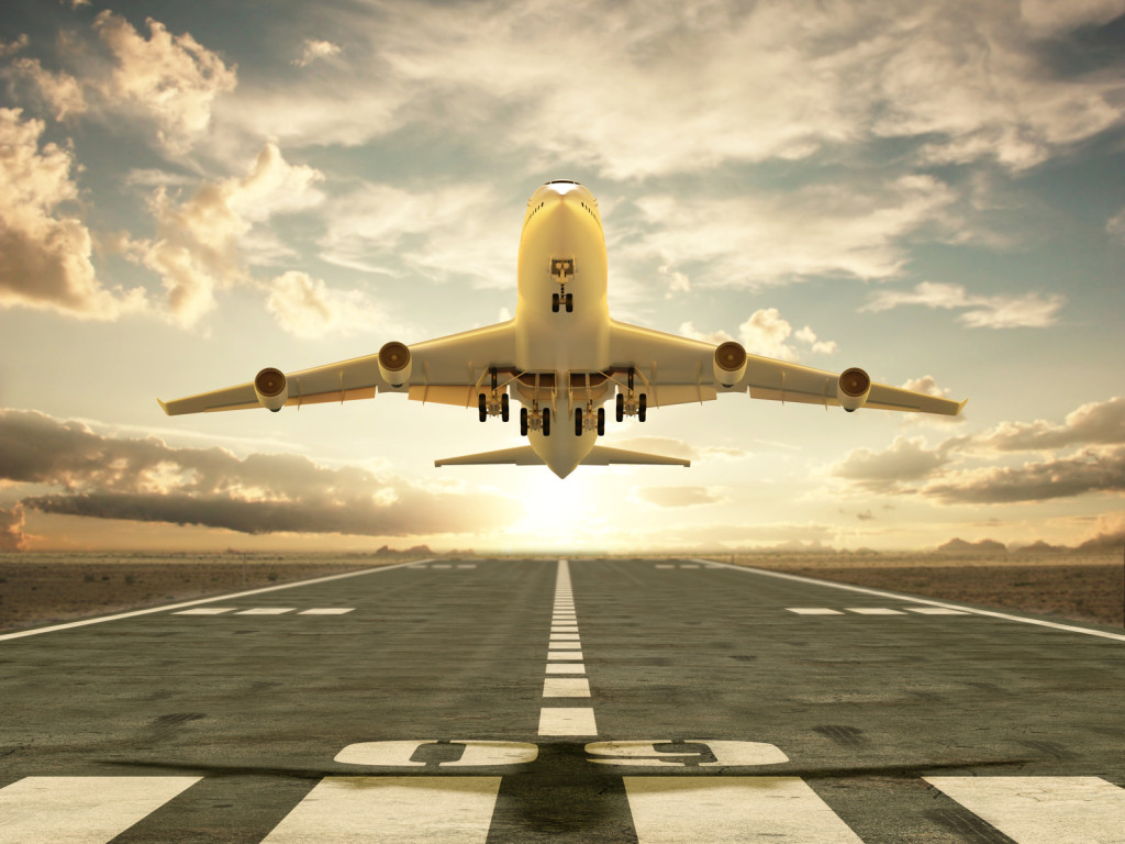 Airplane taking off at sunset