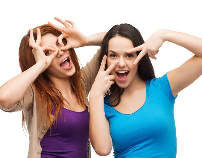 happiness and people concept - two young teenagers making funny faces